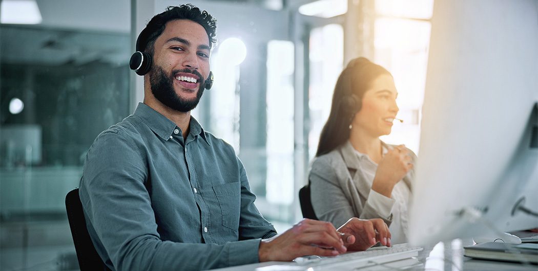 Atendente de suporte com headset sorrindo durante um atendimento
