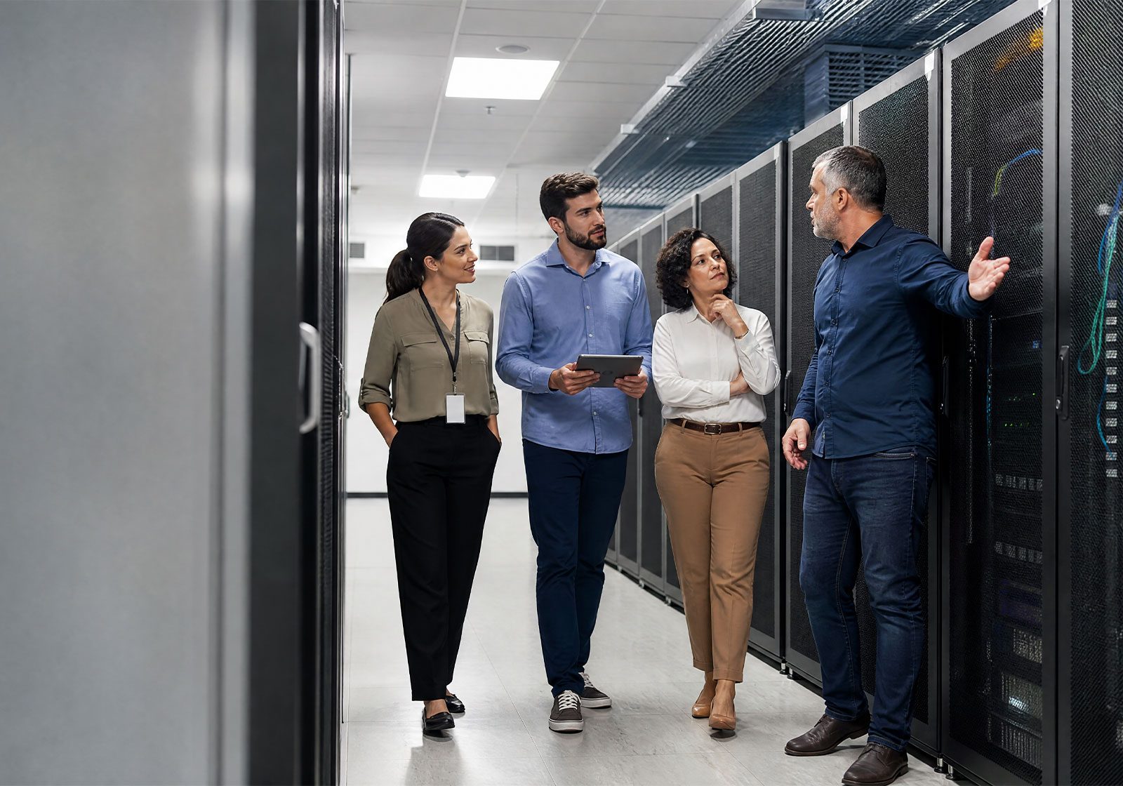 Equipe de tecnologia conversando no corredor de um data center, entre racks de servidores