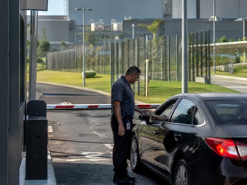 Controle de acesso na portaria de um data center, com cancela e segurança