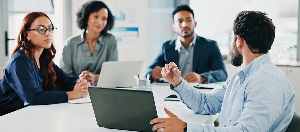 Reunião de negócios com profissionais em volta de uma mesa com notebooks