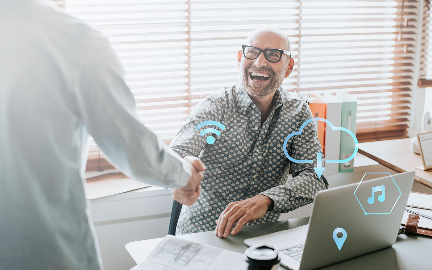 Profissional sorrindo e apertando a mão de um cliente no escritório, com ícones de nuvem e conectividade