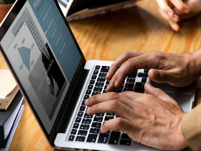Pessoa trabalhando em um notebook sobre a mesa